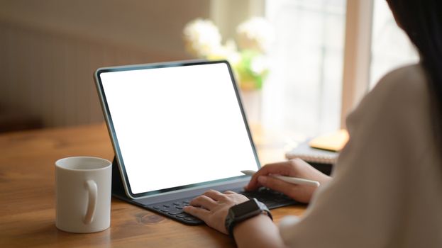 Young business women are using blank screen laptop with coffee cup in modern office.