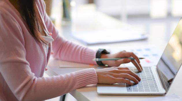 Cropped shot of Young women use laptop in modern personal office.