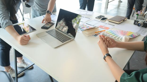 The UX team is designing an application for smartphones with a laptop in a modern office.