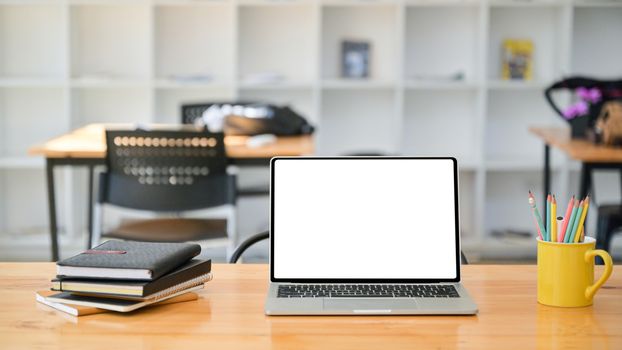 Cropped shot of Laptop with notebooks and stationary on a wooden desk in a modern office.