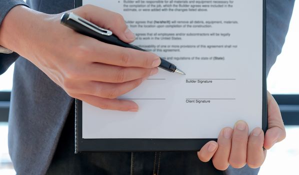 Cropped shot of The contractor pointed the pen at the builder to sign the contract to build the house.