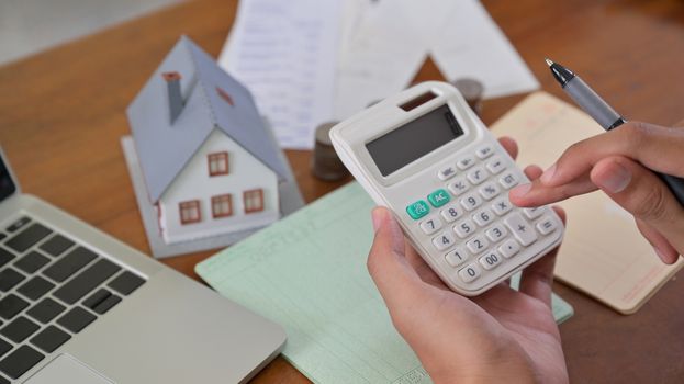 Homeowner use calculator to check home expenses.