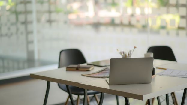 Modern contemporary workplace with laptop and office supplies.