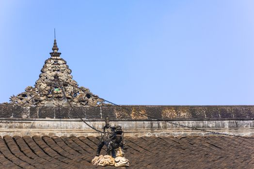 Dragon sculpture in chains on a chinese buddhist temple roof against blue sky, Wenshu Monastery, Chengdu, China