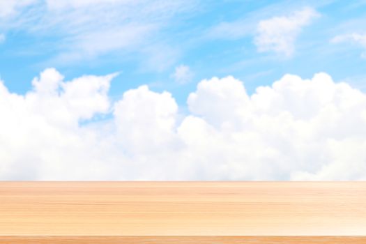 empty wood table floors on blurred blue sky and cloud background, wood table board empty front blur sky blue, wooden plank blank on sky with perspective brown wood table for mock up display products