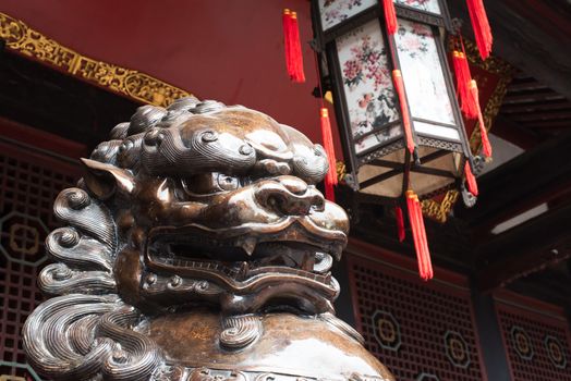 Lion bronze statue in front of a buddhist temple in China