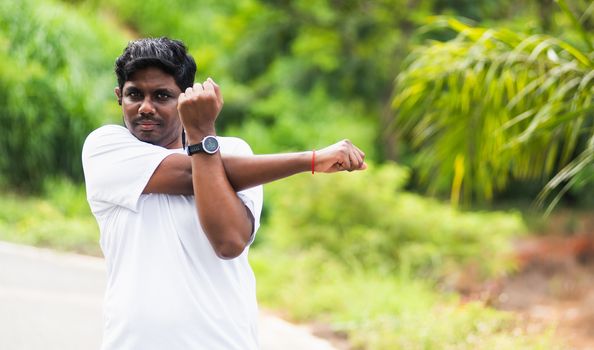 Close up Asian young sport runner black man wear watch he body warming up arms muscles before running at the outdoor street health park, healthy exercise Injury from workout concept