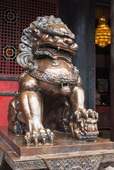 Lion bronze statue in front of a buddhist temple in China