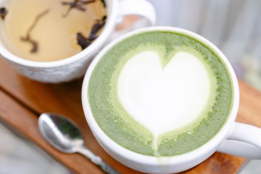 Closeup glass of matcha green tea shape on wood background with vintage color, selective focus