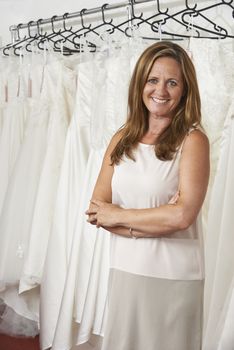 Portrait Of Female Bridal Store Owner With Wedding Dresses