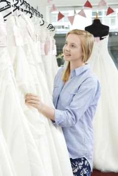 Bride Choosing Dress In Bridal Boutique