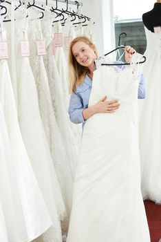 Bride Choosing Dress In Bridal Boutique