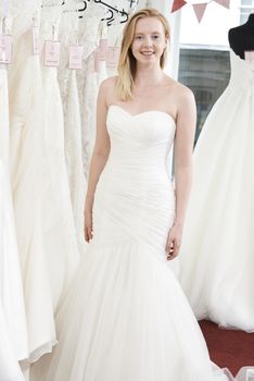 Bride Trying On Wedding Dress In Bridal Boutique