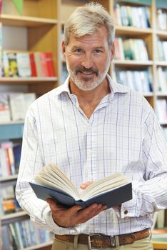 Portrait Of Male Customer Reading Book In Bookstore