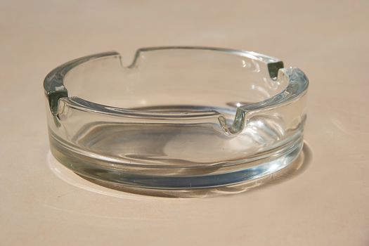 Ashtray Empty glass transparent cigarette tray. Clean clear glassware container for cigar trash. Round shape single classic form of ash tray. Smoke addiction concept. Bad unhealthy habit quitting. 