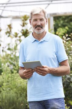 Portrait Of Sales Assistant In Garden Center With Digital Tablet