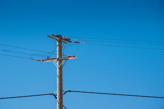 High voltage tower.  electricity wire supply. electrical industry transmission technology against clear blue sky. energy distribution pylon. Power cable line infrastructure pole. Urban construction