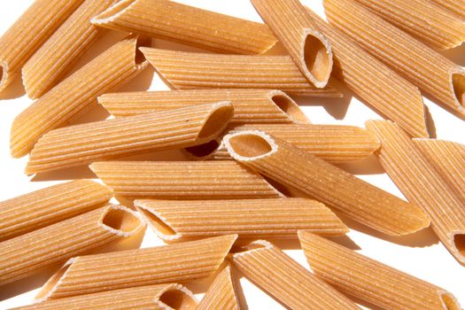 Pasta penne background wallpaper. italian food whole grain lunch ingredient. healthy eating full of carbohydrate. raw grain mediterranean food. Pile of macaroni close-up for healthy lifestyle.