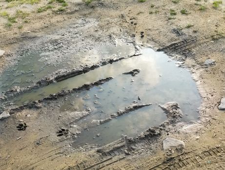 Puddle and mud with tire track texture. Muddy field, dirt road after rain. Impassibility Of Roads. Helplessness concept