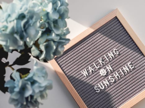Top view on letter board with word Walking on Sunshine. Flat lay concept symbol of warmth and light.