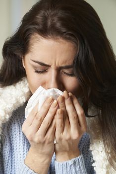 Woman With Cold Holding Tissue And Sneezing