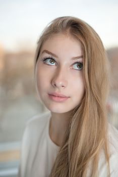 Close up portrait of an attractive teen girl. She is rolling her eyes up and looking.