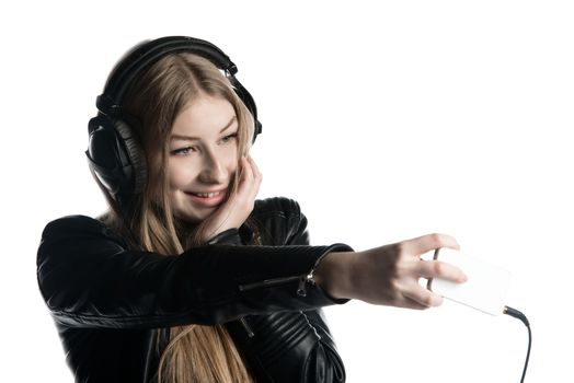 Isolated on white happy face of a girl making selfie and a grimace while listening music in wired headphones