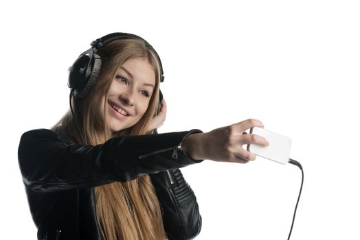 Isolated on white happy face of a girl making selfie and a grimace while listening music in wired headphones
