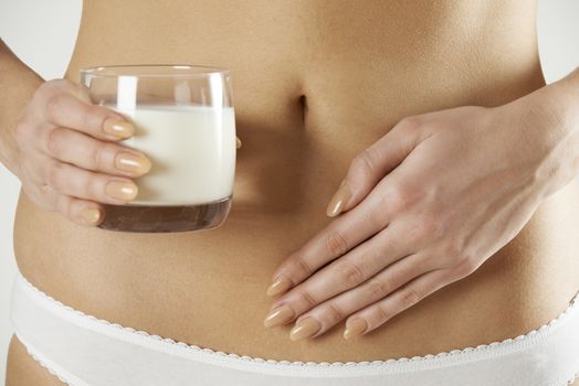 Close Up Of Dairy Intolerant Woman Holding Glass Of Milk