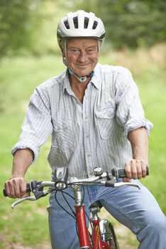 Senior Man Enjoying Cycle Ride In The Countryside