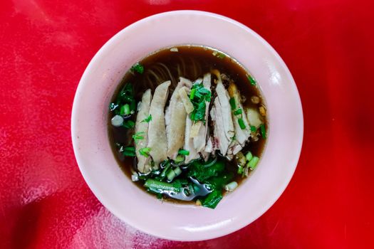 Stewed chicken noodle soup on the red table