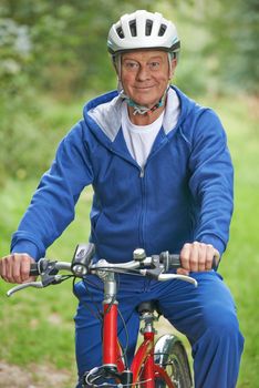 Senior Man Enjoying Cycle Ride In The Countryside