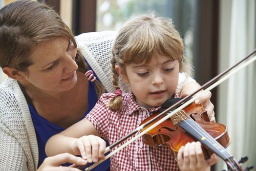 Teacher Helping Young Female Pupil In Violin Lesson