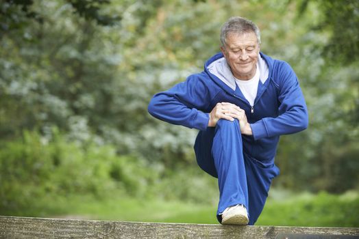 Senior Man Stretching On Countryside Run