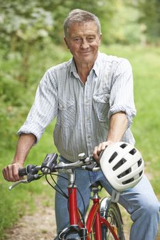 Senior Man Enjoying Cycle Ride In The Countryside