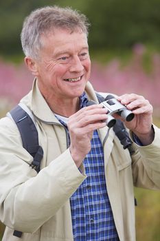 Senior Man On Walk With Binoculars