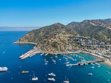 Aerial view of Avalon harbor in Santa Catalina Island with sailboats, fishing boats and yachts moored in calm bay, famous tourist attraction in Southern California, USA