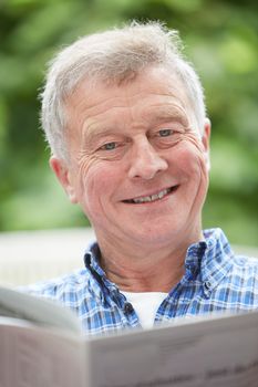 Senior Man Reading Newspaper At Home