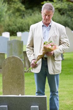 Man Laying Flowers on Grave