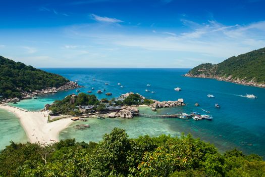 Landscape view point of separated sea across by white sand at front of green mountains under clear sky located at south of Thailand