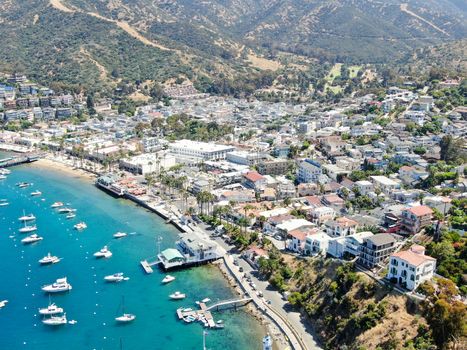 Aerial view of Avalon harbor in Santa Catalina Island with sailboats, fishing boats and yachts moored in calm bay, famous tourist attraction in Southern California, USA