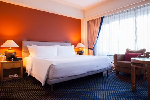 Interior of superior bedroom with white bed and pillow