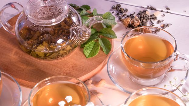 A Cup of green tea and a teapot. Flower tea with fruit slices. Tea ceremony, traditional drink. Afternoon tea, homelike. Flat lay. Oriental, cozy, preparation, heat, tradition, japanese, leafy, herbal
