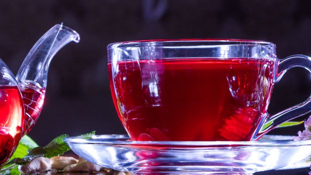 Tea time: cup of tea. Creative layout made of cup of hibiscus tea and tea leafs. Red tea, carcade, karkade, rooibos. Oriental, cozy, ceremony, tradition, japanese, leafy, hygge, autumn, 5 o'clock