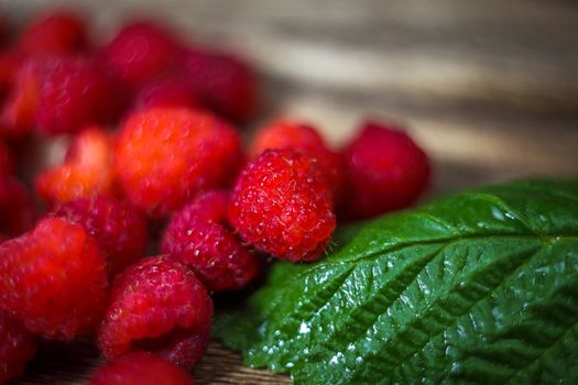 Macro photo food raspberry berry. Texture background ripe pink raspberry berry. Fresh raspberries on a rustic wooden table. Selective focus.