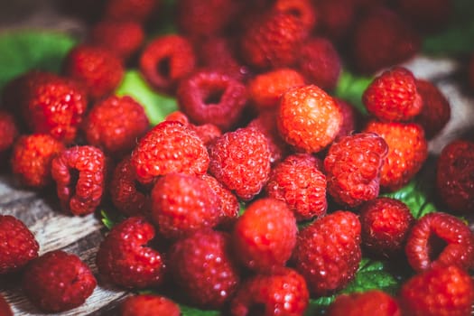 Macro photo raspberry. Texture background ripe pink raspberry. Fresh raspberries on a rustic wooden table. Selective focus.