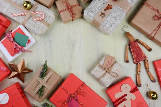 Christmas Gifts, tags, and wrapping supplies on a rustic wood table. Horizontal format from a high angle with copy space.