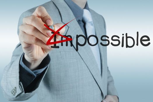 Businessman hand changing the word impossible into possible