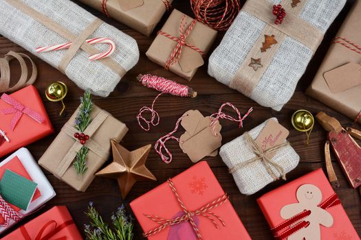 A group of Christmas presents on a dark wood table.