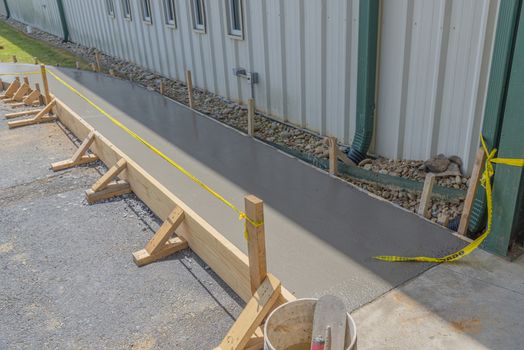 Horizontal shot of a new concrete sidewalk that has just been poured.